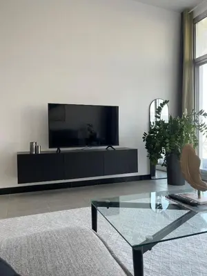 a living room with a flat screen tv on a wall at Specious 1 bd close to Sea Jumeirah in Dubai