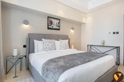 a bedroom with a large bed in a room at Vogue Downtown Mon Reve near Burj Khalifa and Dubai Mall, Two Bedroom plus kids room Apartment with Balcony and Access to all Amenities in Dubai