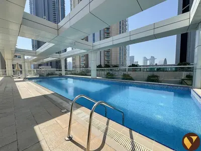 a large swimming pool in a building with tall buildings at Vogue Downtown Mon Reve near Burj Khalifa and Dubai Mall, Two Bedroom plus kids room Apartment with Balcony and Access to all Amenities in Dubai