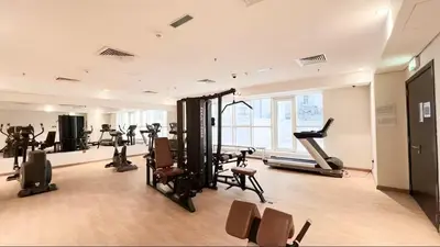 a gym with treadmills and exercise equipment in a building at Vogue Downtown Mon Reve near Burj Khalifa and Dubai Mall, Two Bedroom plus kids room Apartment with Balcony and Access to all Amenities in Dubai