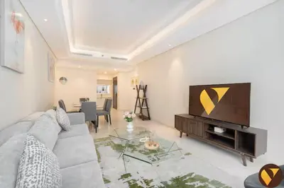 a living room with a couch and a flat screen tv at Vogue Downtown Mon Reve near Burj Khalifa and Dubai Mall, Two Bedroom plus kids room Apartment with Balcony and Access to all Amenities in Dubai