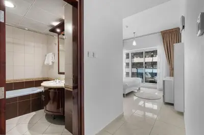 a bathroom with a tub and a sink and a bed at Cozy 1BR with gym & pool in heart of Marina - Opal Tower in Dubai