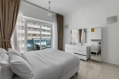a white bedroom with a large bed and a mirror at Cozy 1BR with gym & pool in heart of Marina - Opal Tower in Dubai