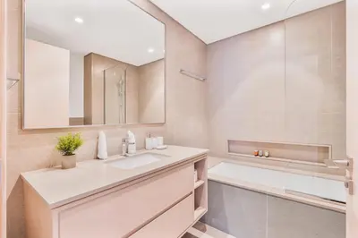a bathroom with a sink and a mirror and a tub at 2Bed with spectacular Burj Khalifa & fountain view in Dubai