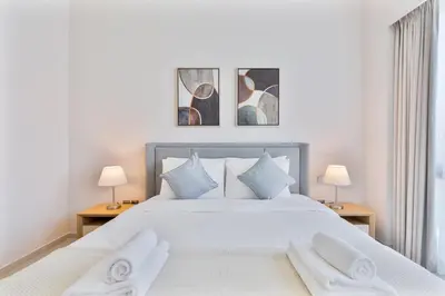 a bedroom with a large white bed with two lamps at 2Bed with spectacular Burj Khalifa & fountain view in Dubai