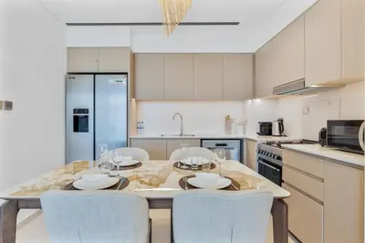 a kitchen with a table with four chairs and a kitchen with at 2Bed with spectacular Burj Khalifa & fountain view in Dubai