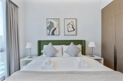 a bedroom with a large white bed with two lamps at 2Bed with spectacular Burj Khalifa & fountain view in Dubai
