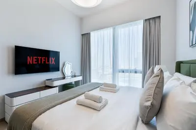 a bedroom with a large white bed with a large window at 2Bed with spectacular Burj Khalifa & fountain view in Dubai