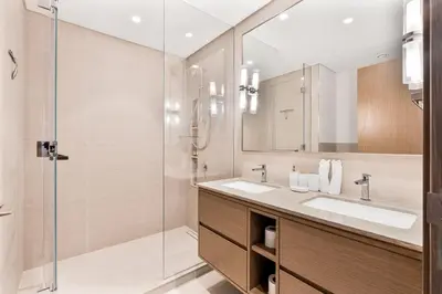 a bathroom with two sinks and a glass shower at 2Bed with spectacular Burj Khalifa & fountain view in Dubai