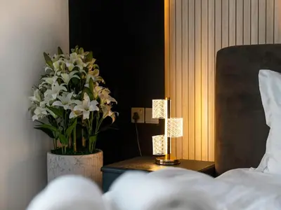a bedroom with a bed and a vase of white flowers at 2BR balcony Downtown with Burj Khalifa and Fountain View in Dubai