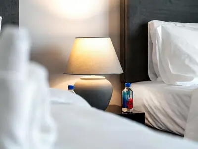 a lamp sitting on a table next to two beds at Stylish 2 bedroom - Marina Views - Private Beach in Dubai
