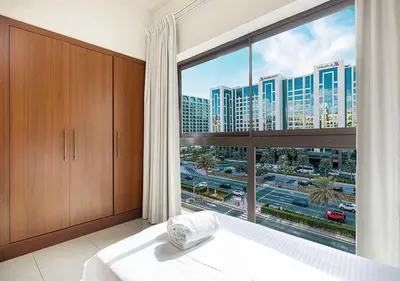a bedroom with a large window with a view of a city at Cozy 2 Br Heart of Palm Jumeirah in Dubai