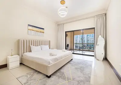 a bedroom with a large bed and a large window at Cozy 2 Br Heart of Palm Jumeirah in Dubai