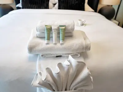two towels and two toothbrushes sitting on top of a bed at Golf View Modern Comfort Perfect for 3 Guests in Dubai