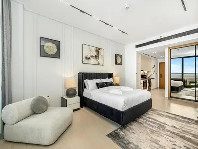 a bedroom with a bed and a chair at Modern Studio with Jacuzzi and Premium Amenities in Dubai