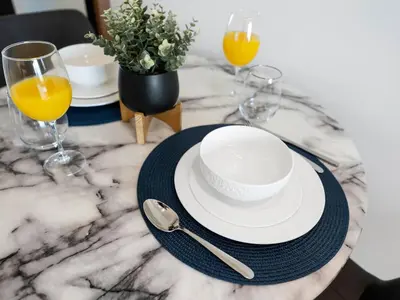 a table with two glasses and a plate and spoon at Modern Studio with Jacuzzi and Premium Amenities in Dubai