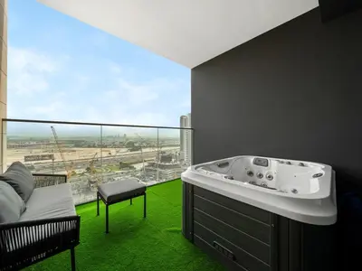 a bathroom with a bath tub and a large window at Modern Studio with Jacuzzi and Premium Amenities in Dubai