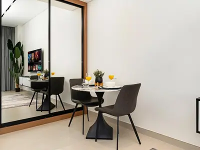 a dining room with a table and two chairs at Modern Studio with Jacuzzi and Premium Amenities in Dubai