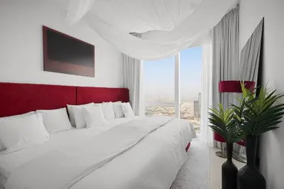 a bedroom with a large bed with a large window at Luxury Apartments at Grande with Burj Khalifa & Fountain View Walk to Dubai Mall, Private Cinema in Dubai