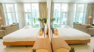 a large bed in a room with windows at Modern studio in Business Bay- 5 min to Dubai Mall in Dubai