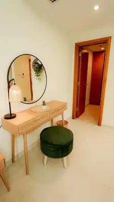 a table with a mirror and a green ottoman at Modern studio in Business Bay- 5 min to Dubai Mall in Dubai