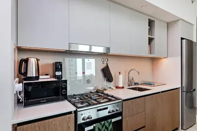 a kitchen with a stove and a microwave at Homey 1BR apartment in Creek Harbour in Dubai