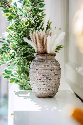 a vase sitting on a table with a plant at Homey 1BR apartment in Creek Harbour in Dubai