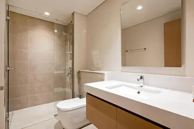 a bathroom with a toilet and a sink and a shower at Commodious 3BR Apartment Canal View Creek Harbor in Dubai