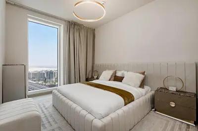 a bedroom with a large bed and a large window at Commodious 3BR Apartment Canal View Creek Harbor in Dubai