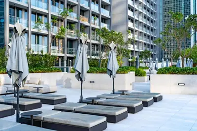 a row of benches with umbrellas in front of a building at Smart Studio in Business Bay Near Burj Khalifa in Dubai