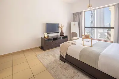 a bedroom with a large bed and a flat screen tv at Frank Porter - Sadaf 7, JBR in Dubai