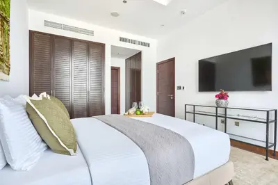 a bedroom with a white bed with a flat screen tv at Frank Porter - Tiara Residence Diamond North 4 in Dubai