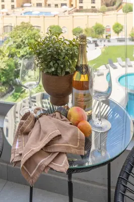 a glass table with a bottle of wine and two glasses at Frank Porter - Marina Wharf 1 in Dubai