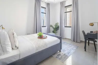 a bedroom with a bed with a desk and a chair at Frank Porter - Marina Wharf 1 in Dubai