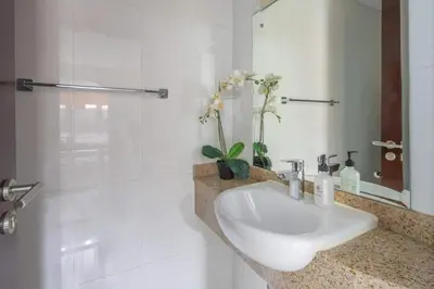 a white bathroom with a sink and a mirror at Frank Porter - Lakepoint N2 in Dubai