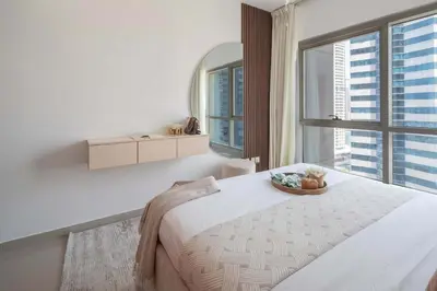 a bedroom with a large bed and a large window at Frank Porter - Lakepoint N2 in Dubai