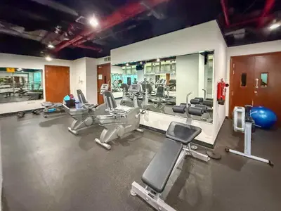 a gym with a bunch of chairs and mirrors at Frank Porter - Lakepoint N2 in Dubai
