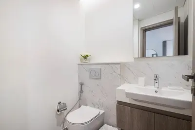a bathroom with a sink and a toilet and a mirror at Marina Horizon by LIV High Floor 1BR, For 5 Guests, Dual Gyms & Marina View in Dubai