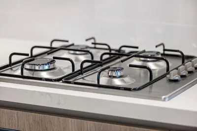 a gas stove top with four burners on it at Marina Horizon by LIV High Floor 1BR, For 5 Guests, Dual Gyms & Marina View in Dubai