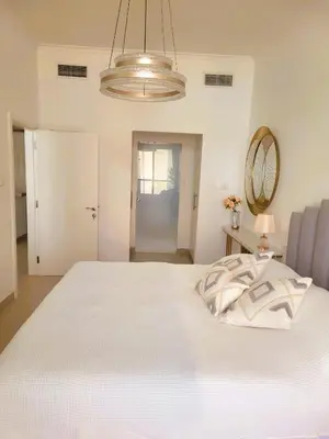 a bedroom with a large white bed with a chandelier at Apartment in Dubai Marina with Sea View & Balcony & Pool in Dubai