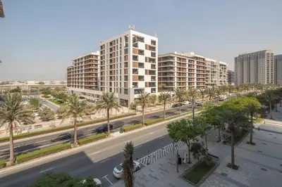an empty city street with palm trees and buildings at Frank Porter - Acacia, Park Heights Tower A in Dubai