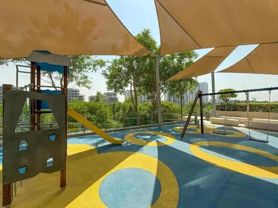 a playground with a slide and a swing at Frank Porter - Acacia, Park Heights Tower A in Dubai