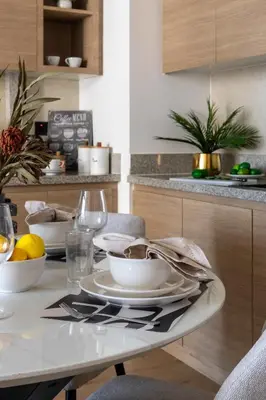 a table with plates and bowls on it in a kitchen at Frank Porter - Acacia, Park Heights Tower A in Dubai