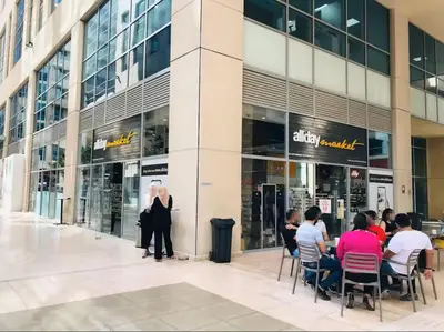 a group of people sitting outside of a shopping mall at Vogue Business Bay - Bay Square Close to Downtown, Burj Khalifa and Dubai Mall, Studio Apartment with Balcony and City View, Access to all Amenities in Dubai