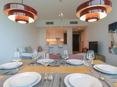a dining room table with plates and wine glasses at HiGuests - 2 BR Escape Golf View Haven in The Greens in Dubai