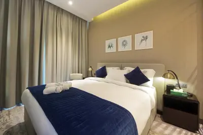 a bedroom with a large bed with a blue blanket at King Bed Suite - Canal Views - Pool, Gym & Balcony in Dubai