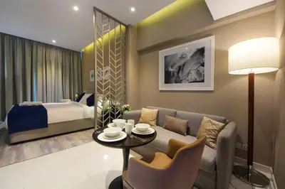 a living room with a couch and a bed at King Bed Suite - Canal Views - Pool, Gym & Balcony in Dubai
