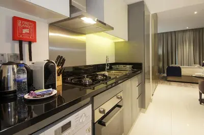 a kitchen with a stove and a counter top at King Bed Suite - Canal Views - Pool, Gym & Balcony in Dubai