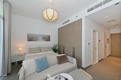 a living room with a bed and a couch at New Cozy Studio, Ideal for 2 in Kensington Waters in Dubai
