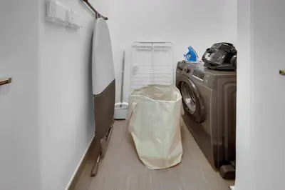 a kitchen with a washing machine and a refrigerator at New Cozy Studio, Ideal for 2 in Kensington Waters in Dubai